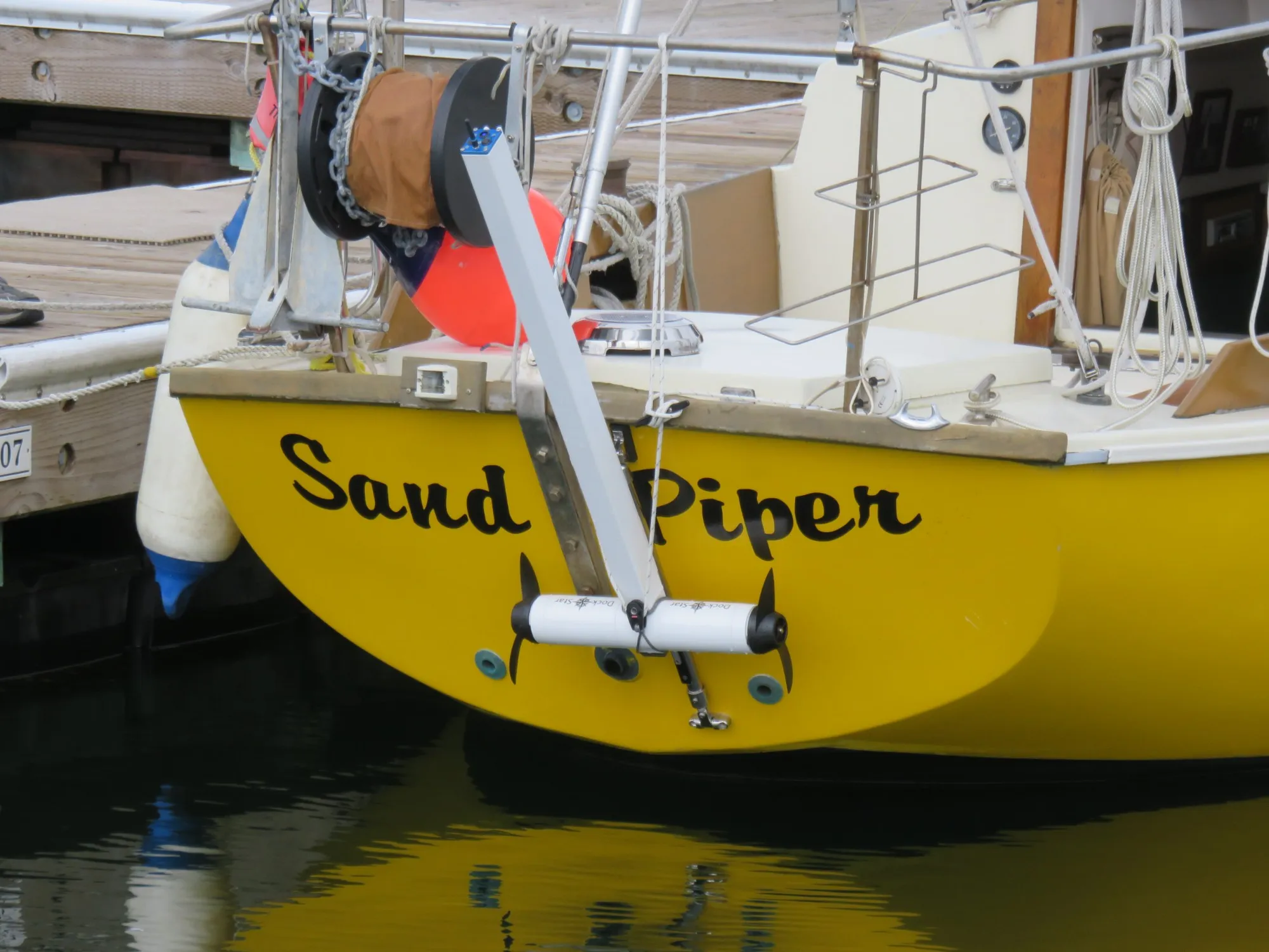 A DockStar on a track on the transom of a sailboat, tilted up at the dock.